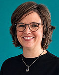 Portraifoto zeigt Katrin Hahn-Laudenberg mit schwarzem Oberteil und Kette vor türkisem Hintergrund
